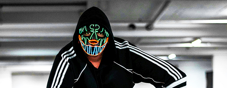 A thief conceals his identity with a neon mask