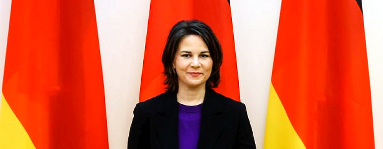 German Foreign Minister Annalena Baerbock, standing in front of some German flags (“Bundesflagge”)