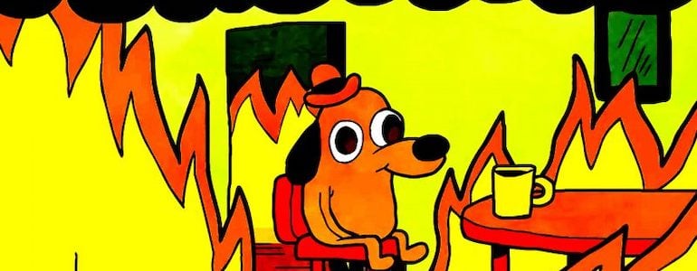 KC Green’s seminal “This Is Fine” cartoon, where a dog drinks coffee, seemingly oblivious to a fire that’s engulfing the house.