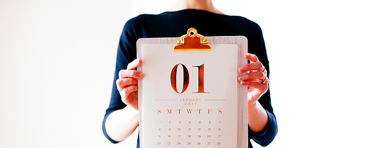 A woman holds up a calendar